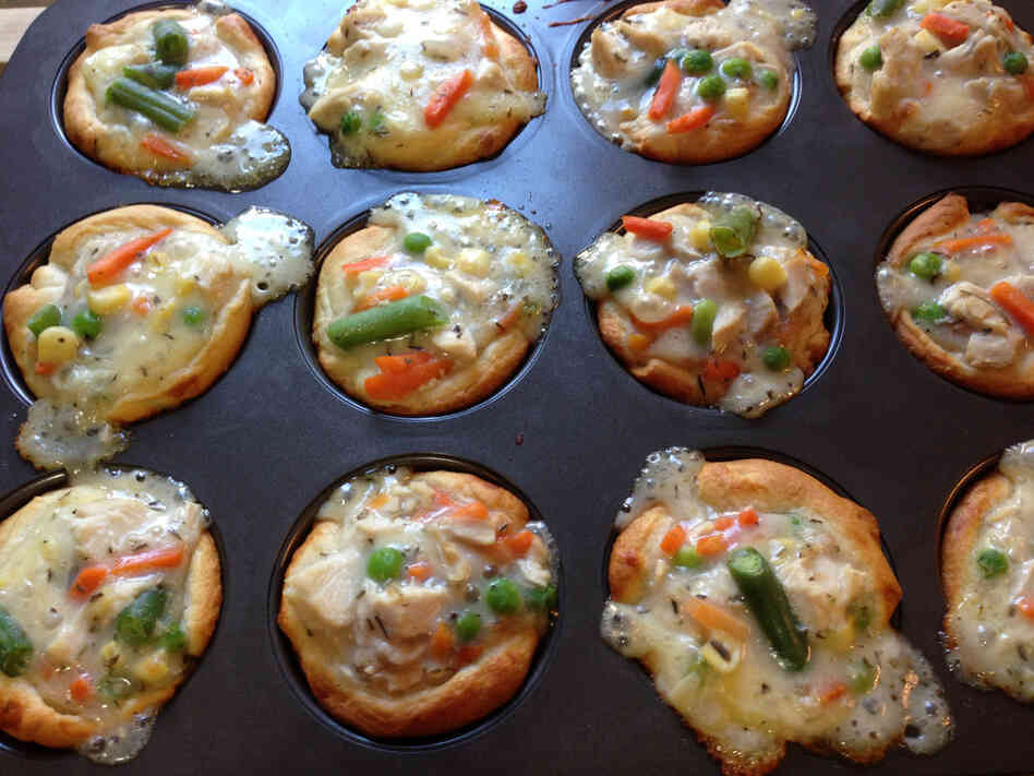 Bubbling chicken potpie cupcakes, fresh out of the oven. Crescent roll dough creates a shell for the chicken filling.
