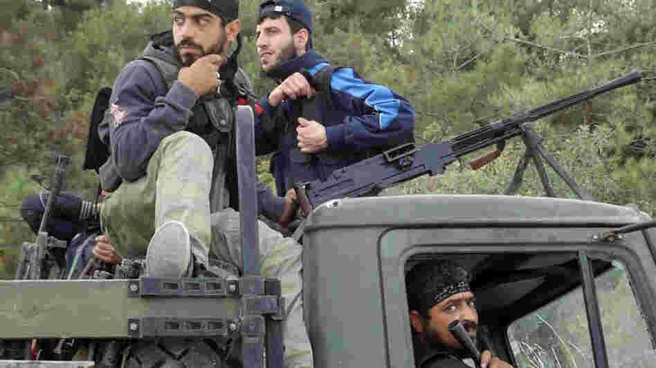 Rebels of the Free Syrian Army sit on top of a military truck captured from the Syrian army in the village of Khirbet al-Joz along the Turkish border in northern Syria on Oct. 7, in this photo provided by the Edlib News Network, ENN. The rebels hope to put a civilian council in charge and believe such moves could help pave the way for a secular, democratic Syria.