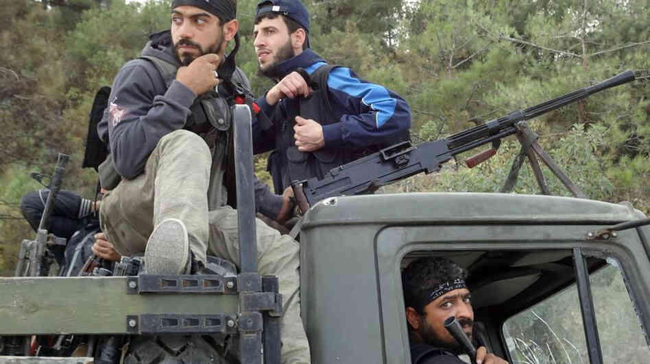 Rebels of the Free Syrian Army sit on top of a military truck captured from the Syrian army in the village of Khirbet al-Joz along the Turkish border in northern Syria on Oct. 7, in this photo provided by the Edlib News Network, ENN. The rebels hope to put a civilian council in charge and believe such moves could help pave the way for a secular, democratic Syria.