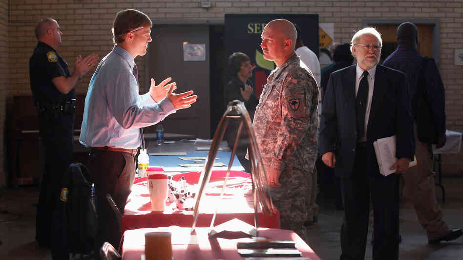 Sgt. Ben Roberts (center), recently returned from Afghanistan, speaks with Chick-fil-A manager Michael Sims at a military job fair in Columbia, S.C., in January.