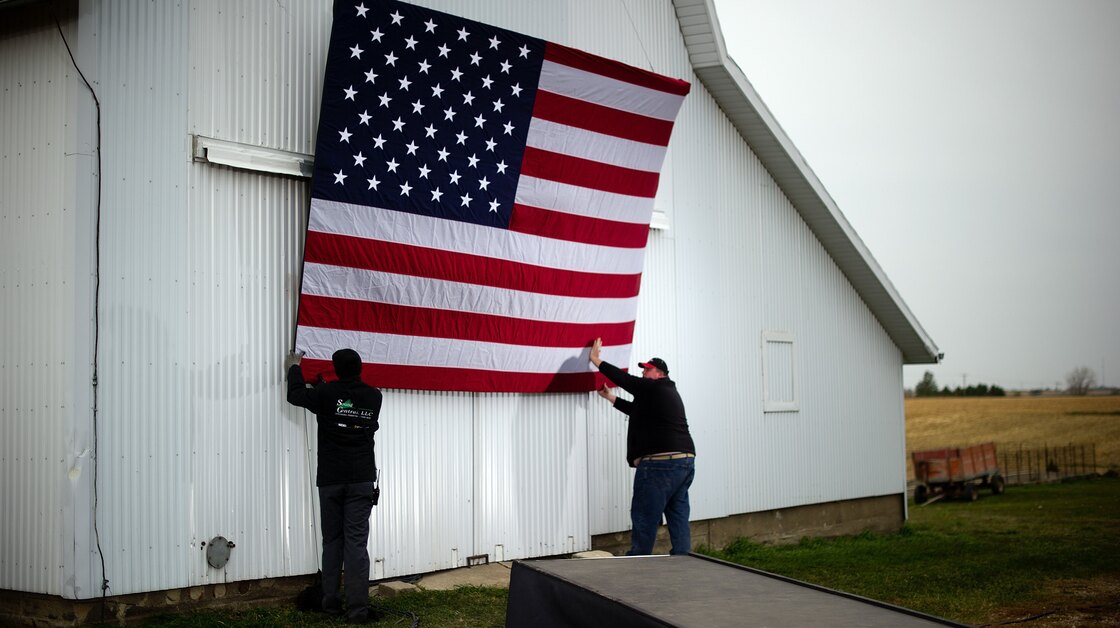 Aides tack up an American flag to a barn at the James Koch farm in Van Meter, Iowa, on Oct. 9, ahead of Republican presidential candidate Mitt Romney's arrival for a rally.