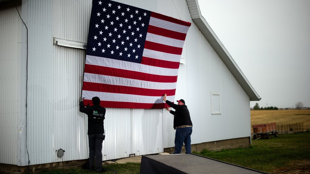 Aides tack up an American flag to a barn at the James Koch farm in Van Meter, Iowa, on Oct. 9, ahead of Republican presidential candidate Mitt Romney's arrival for a rally.