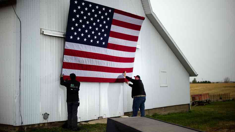 Aides tack up an American flag to a barn at the James Koch farm in Van Meter, Iowa, on Oct. 9, ahead of Republican presidential candidate Mitt Romney's arrival for a rally.