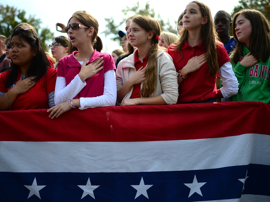 The crowd joins Republican Mitt Romney in singing the national anthem at a rally Wednesday in Chesapeake, Va.