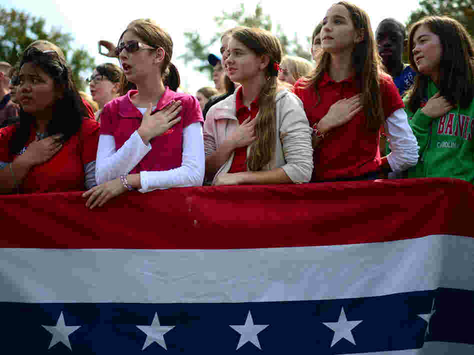 The crowd joins Republican Mitt Romney in singing the national anthem at a rally Wednesday in Chesapeake, Va.