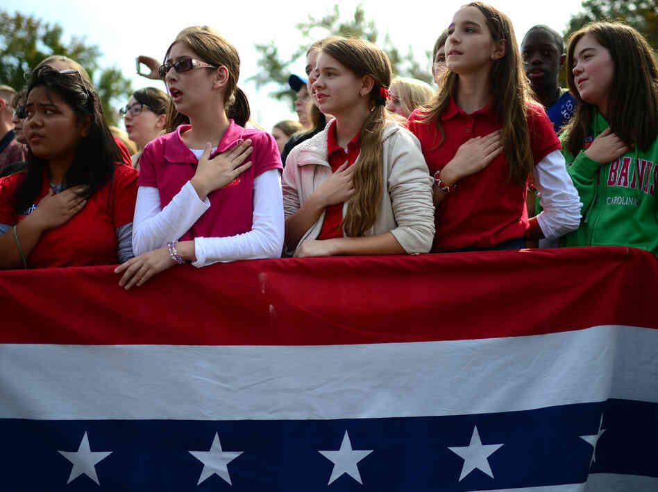 The crowd joins Republican Mitt Romney in singing the national anthem at a rally Wednesday in Chesapeake, Va.