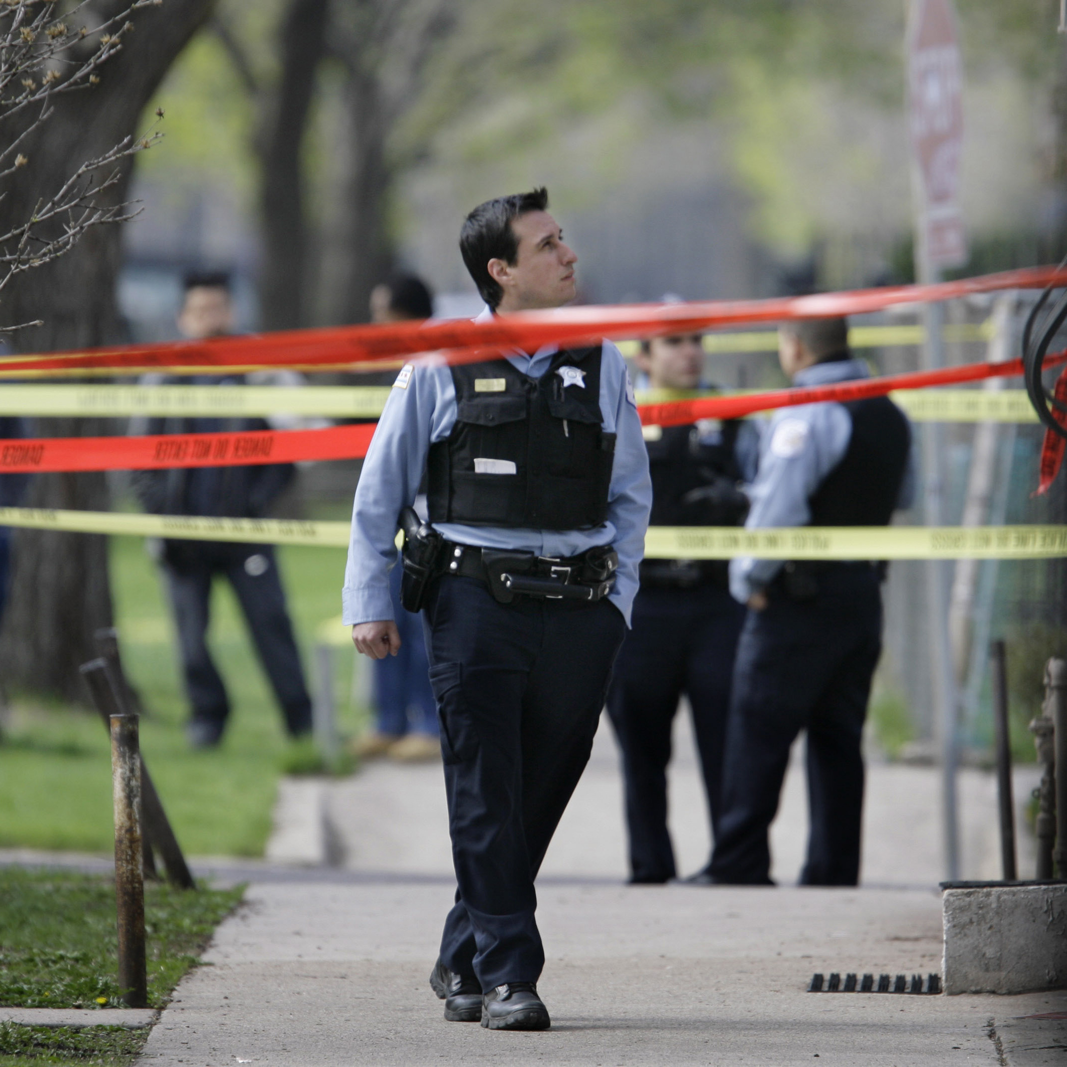Police officers work a crime scene where they discovered the bodies of three shooting victims at a home on Chicago's Southwest side in April 2008. The number of shootings and homicides in the city is increasing, but many of these crimes are going unsolved.