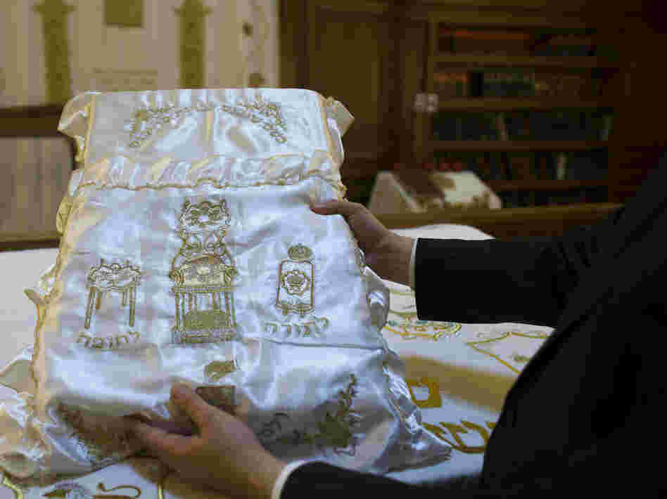 A rabbi holds up a pillow used during ritual circumcision at a synagogue in Berlin.