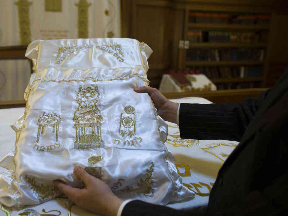 A rabbi holds up a pillow used during ritual circumcision at a synagogue in Berlin.