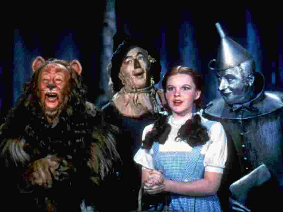 Bert Lahr as the Cowardly Lion, Ray Bolger as the Scarecrow, Judy Garland as Dorothy, and Jack Haley as the Tin Man in The Wizard Of Oz.