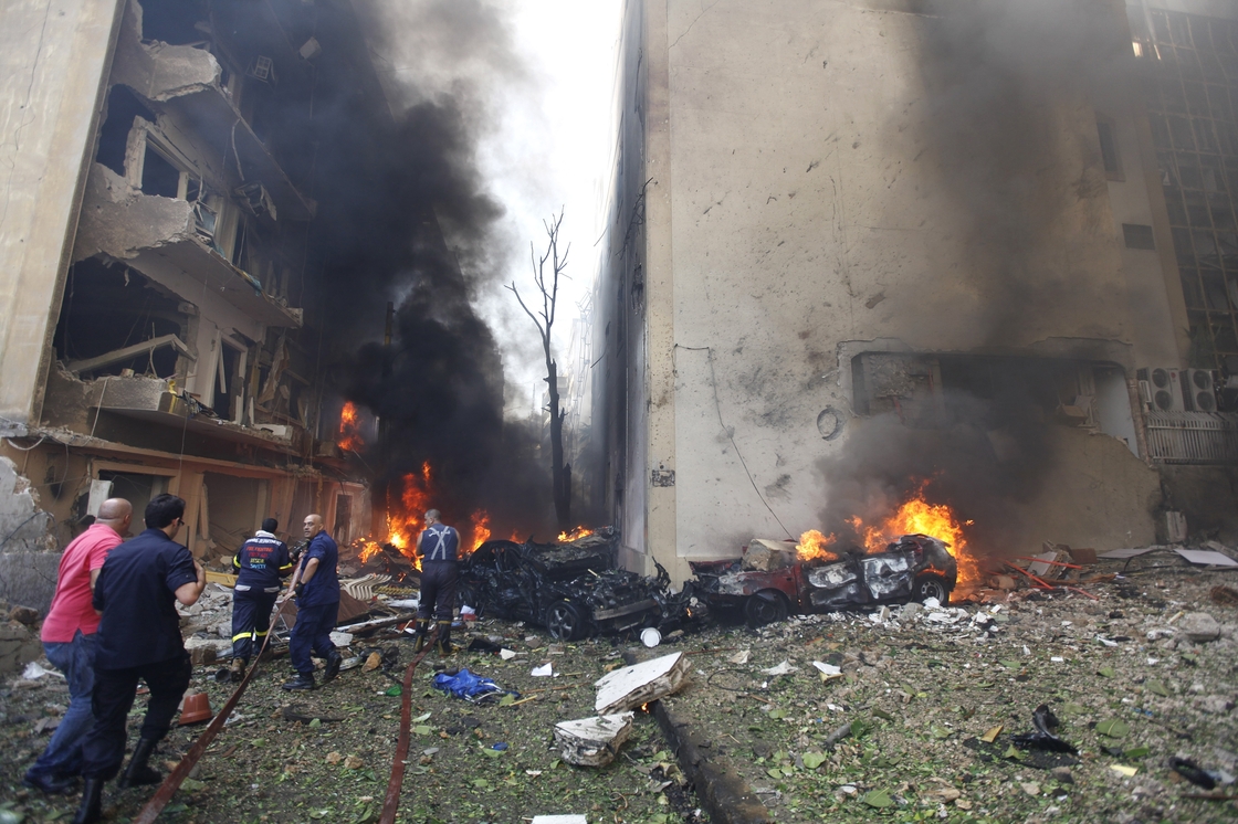 Lebanese firefighters extinguish burning cars in Beirut following a huge bomb explosion.