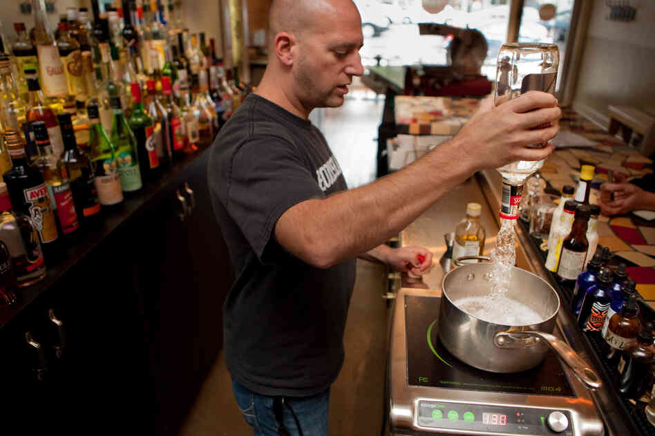 Josh Berner of Ripple, a bar and restaurant in Washington, D.C., pours a bottle of gin into a pot over a very low heat.