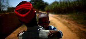 Ado Ibrahim carries his son Aminu through a village in northern Nigeria. Aminu was paralyzed by polio in August. Ado Ibrahim carries his son Aminu through a village in northern Nigeria. Aminu was paralyzed by polio in August.