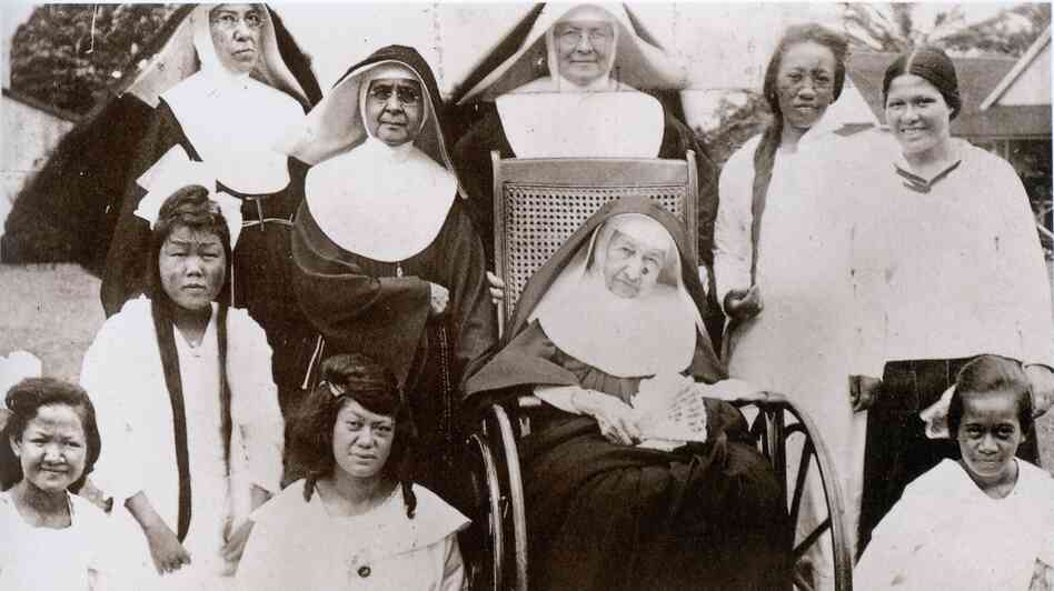 Mother Marianne Cope (in wheelchair) with other nuns and the women and girls of Bishop Home in Kalaupapa, Hawaii, shortly before her death in 1918.