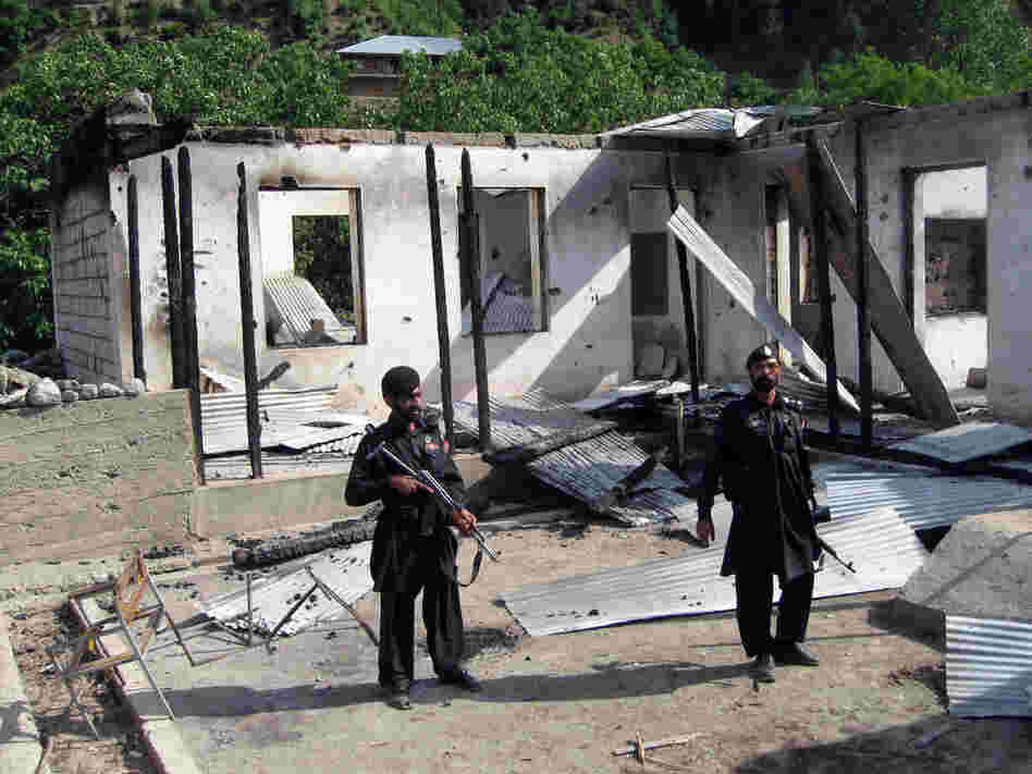 Pakistani security personnel stand guard in front of a burnt-out school following an attack by the Pakistani Taliban in the northwestern district of Upper Dir in June 2011. The Taliban have destroyed many schools in northwestern Pakistan.