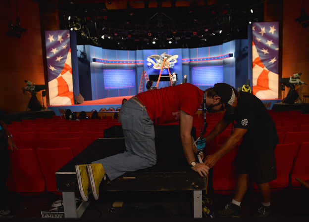 Crew work to put finishing touches on the stage a day ahead of the third and final presidential debate at Lynn University in Boca Raton, Fla.