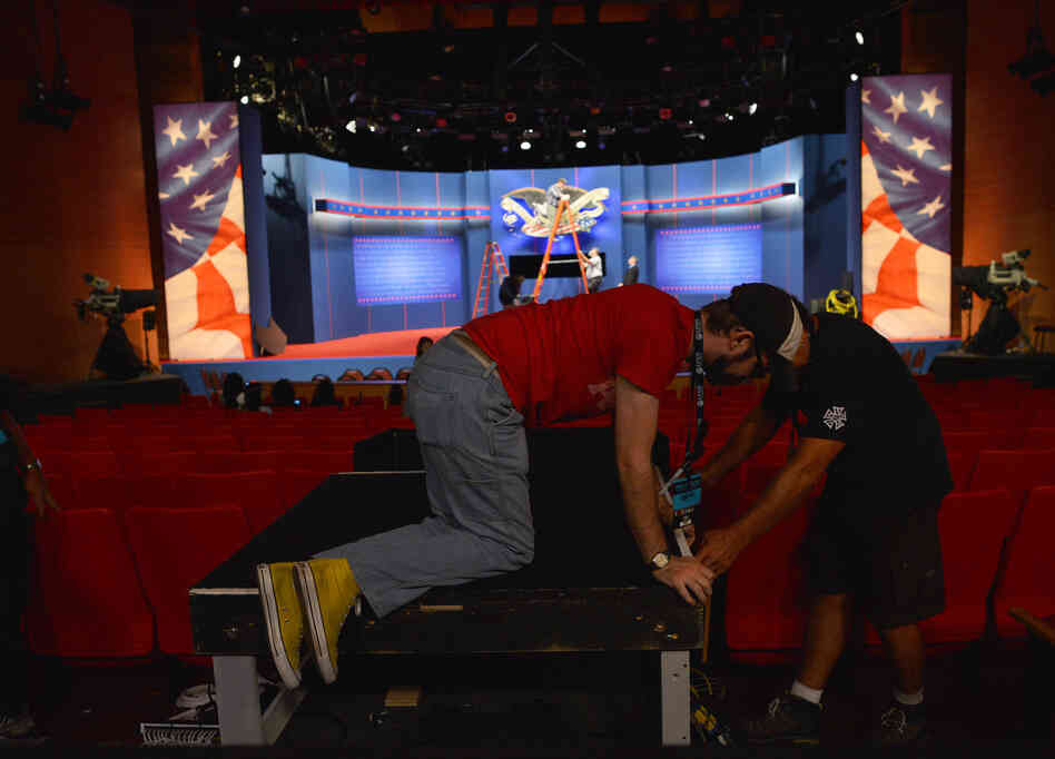Crew work to put finishing touches on the stage a day ahead of the third and final presidential debate at Lynn University in Boca Raton, Fla.