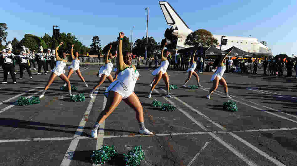 Inglewood High School cheerleaders perform in front of the Space Shuttle Endeavour as it is transported through the streets of Inglewood and Los Angeles on October 13.