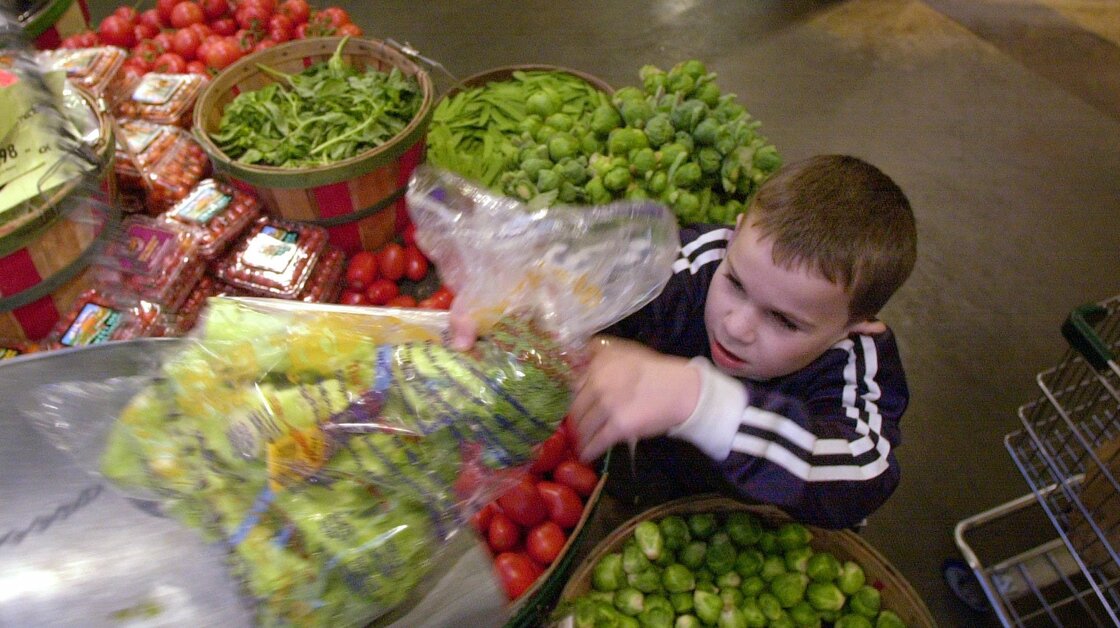 Parents now have more advice to consider when it comes to choosing organic foods. Here, Theo Shriver, 6, weighs organic produce at the Puget Consumers Co-op in Seattle.