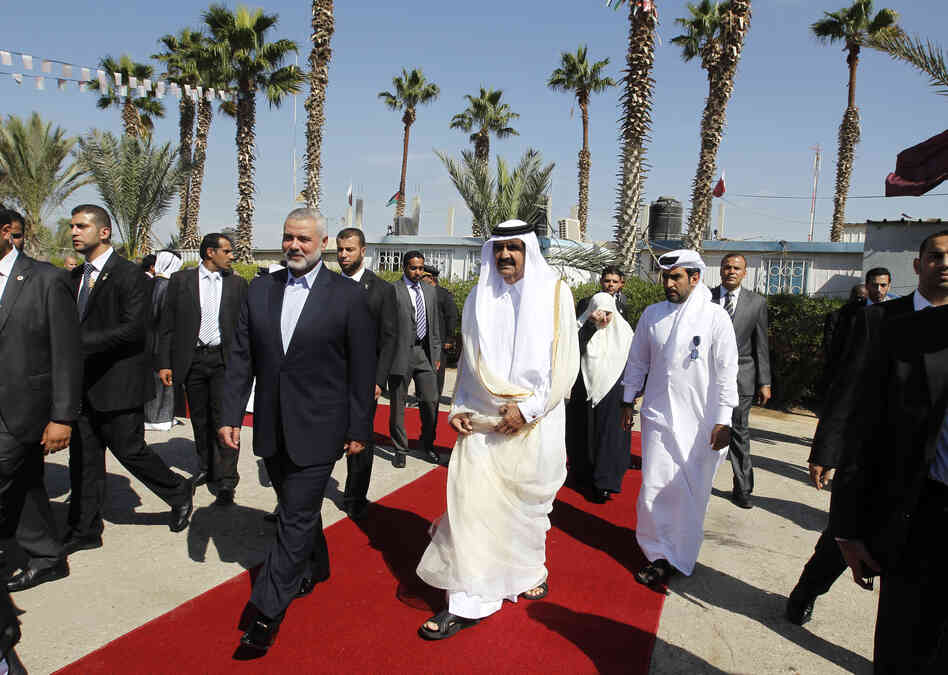 Qatari Emir Sheikh Hamad bin Khalifa al-Thani (center right) walks alongside Gaza's Hamas prime minister Ismail Haniya (center left) during a welcome ceremony at the Rafah border crossing with Egypt on Tuesday. Qatari Emir Sheikh Hamad bin Khalifa al-Thani (center right) walks alongside Gaza's Hamas prime minister Ismail Haniya (center left) during a welcome ceremony at the Rafah border crossing with Egypt on Tuesday.