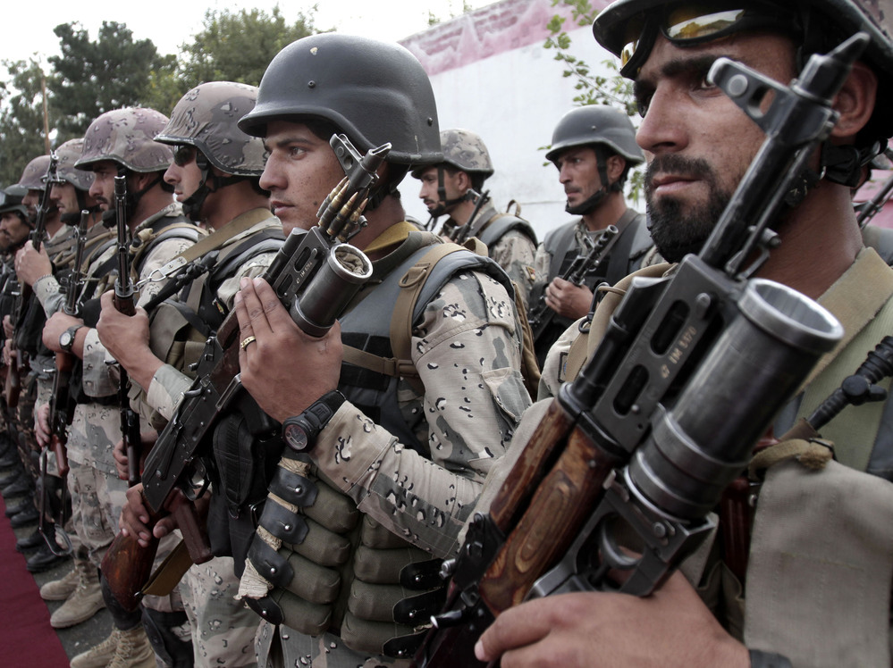 Afghan soldiers stand at attention during a ceremony transferring authority from NATO-led troops to Afghan security forces in Afghanistan's Kunar province. The transfer of responsibility for security from NATO-led ISAF forces to Afghan troops is scheduled to be completed by the end of 2014.