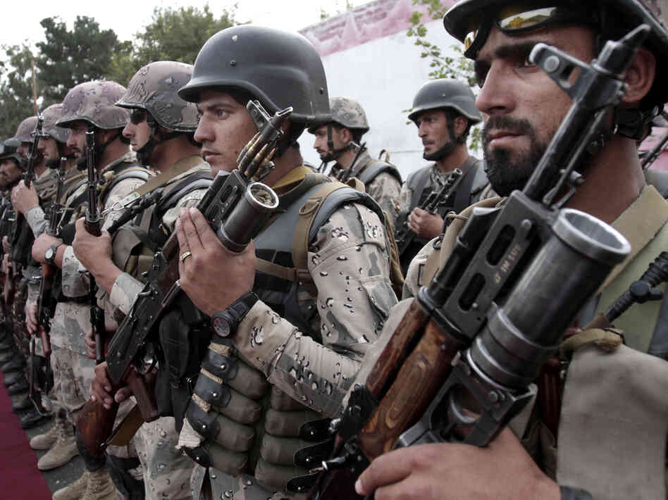 Afghan soldiers stand at attention during a ceremony transferring authority from NATO-led troops to Afghan security forces in Afghanistan's Kunar province. The transfer of responsibility for security from NATO-led ISAF forces to Afghan troops is scheduled to be completed by the end of 2014.