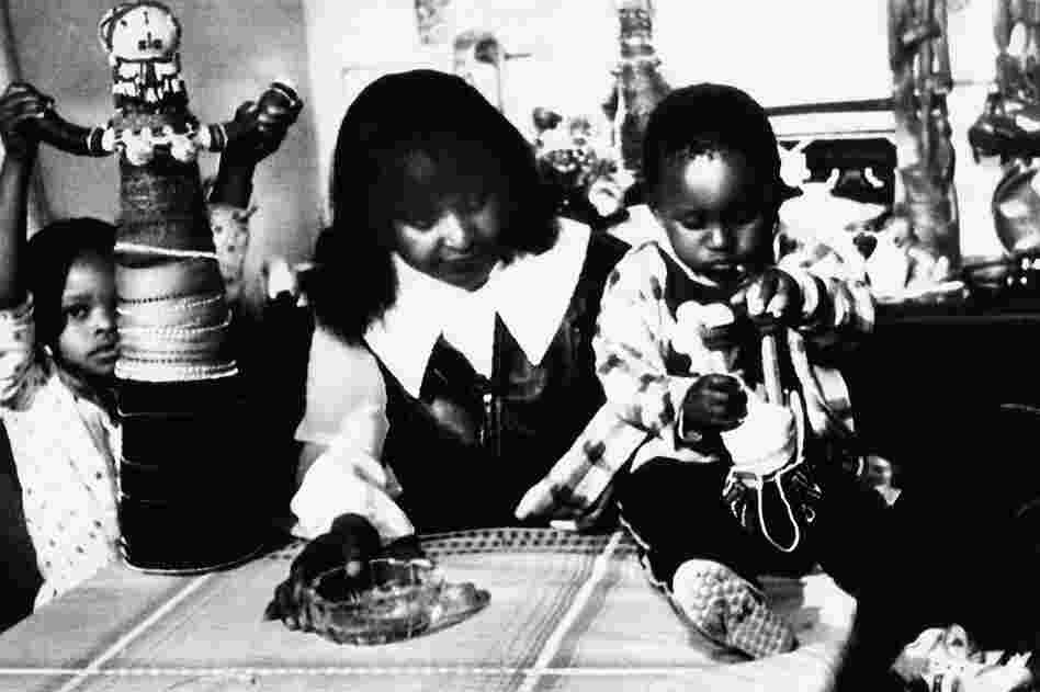Winnie Mandela is seen with two of her grandchildren on Dec. 22, 1985, in Soweto, South Africa, after being forcibly removed from her home the day before. She was later arrested again the same day by South African police.