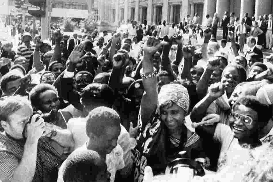 Winnie Mandela (wearing a turban) is mobbed by chanting supporters as she leaves the Supreme Court on Jan. 8, 1986, in Johannesburg, after she began a court suit seeking to overturn a government order banning her from her Soweto home.
