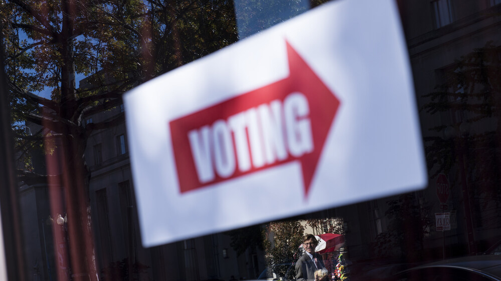 A sign directing voters to a polling place is seen during the first day of early voting on Monday in Washington, D.C.