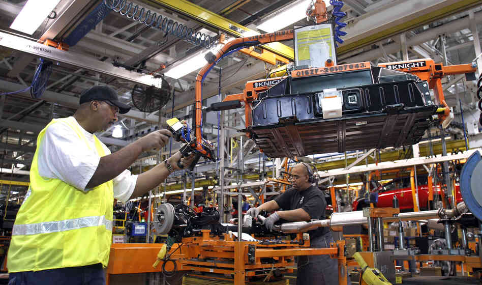 WAYNE, MI - DECEMBER 14: A worker demonstrates the installation of a battery pack for a Ford Focus on the assembly line at the Ford Motor Co.'s Michigan Assembly Plant December 14, 2011 in Wayne, Michigan. WAYNE, MI - DECEMBER 14: A worker demonstrates the installation of a battery pack for a Ford Focus on the assembly line at the Ford Motor Co.'s Michigan Assembly Plant December 14, 2011 in Wayne, Michigan.