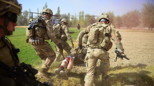U.S. soldiers carry a comrade injured by an improvised explosive device, or IED, in Logar province, south of Kabul, on Oct. 13. Roadside bombs are one of the biggest threats facing U.S. and Afghan troops, and insurgents keeping finding inventive ways to disguise them.