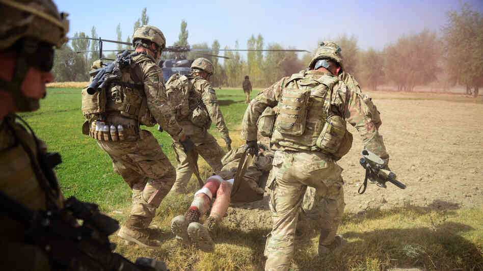 U.S. soldiers carry a comrade injured by an improvised explosive device, or IED, in Logar province, south of Kabul, on Oct. 13. Roadside bombs are one of the biggest threats facing U.S. and Afghan troops, and insurgents keeping finding inventive ways to disguise them.