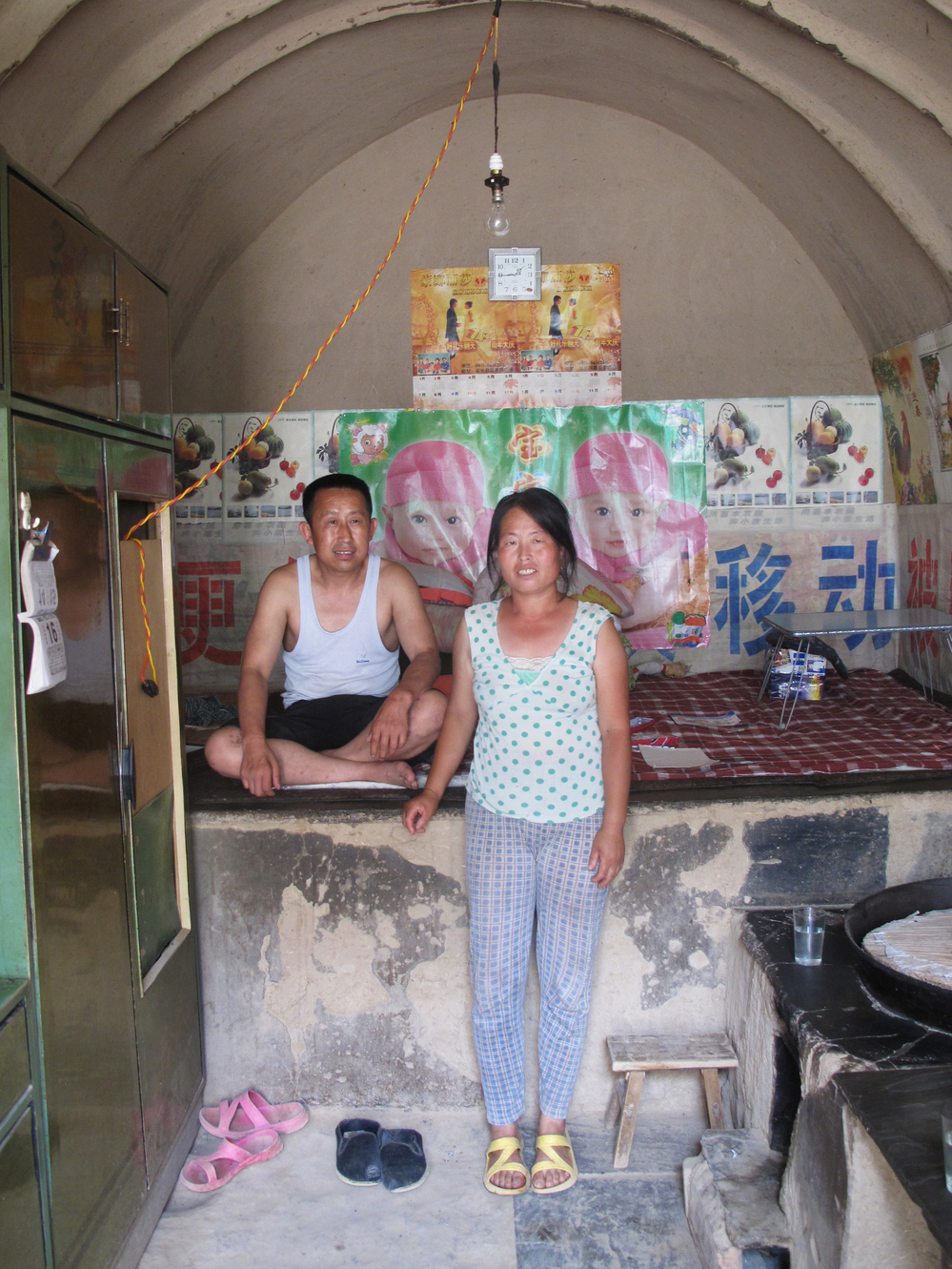 Guo Haiyun, 46, and his wife in their cave home, not far from the revolutionary stronghold of Yan'an. He says he probably only has two or three yuan in cash at home, while he has taken out bank debts he can't return to pay for his daughter's university education.
