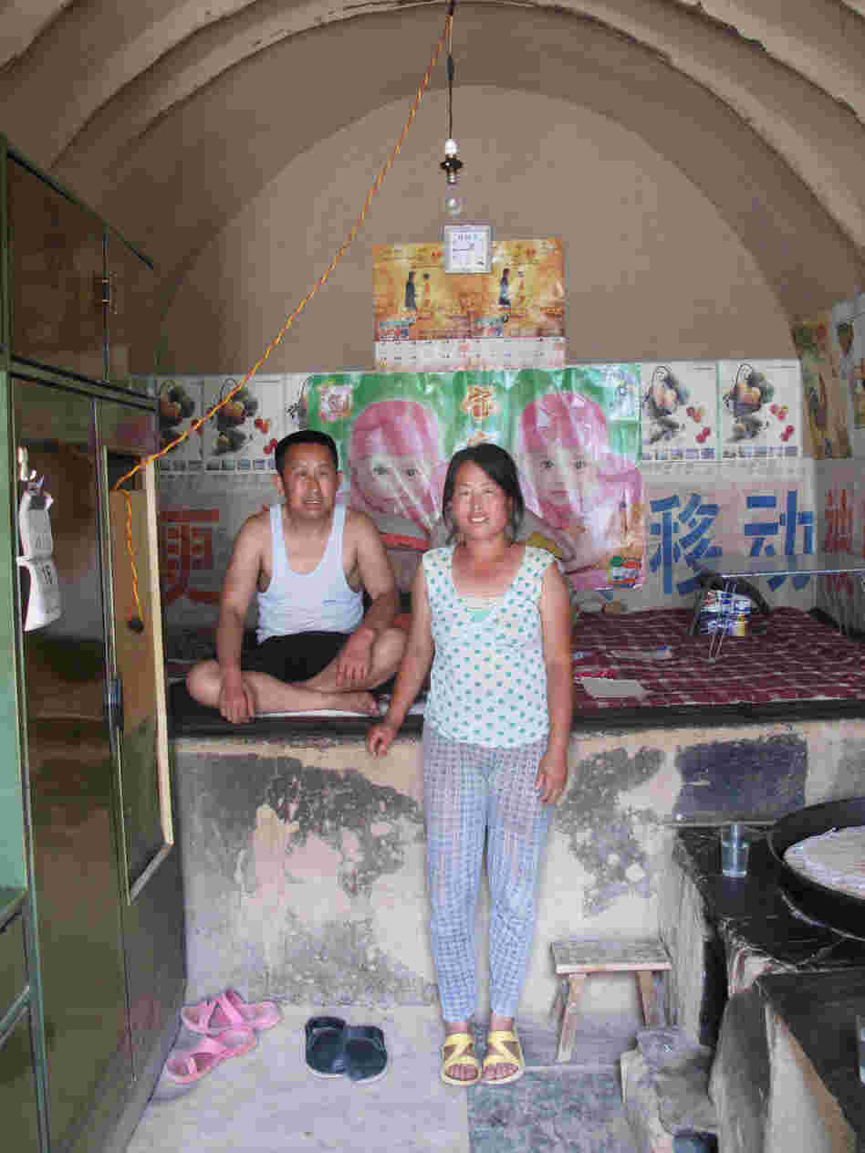 Guo Haiyun, 46, and his wife in their cave home, not far from the revolutionary stronghold of Yan'an. He says he probably only has two or three yuan in cash at home, while he has taken out bank debts he can't return to pay for his daughter's university education.