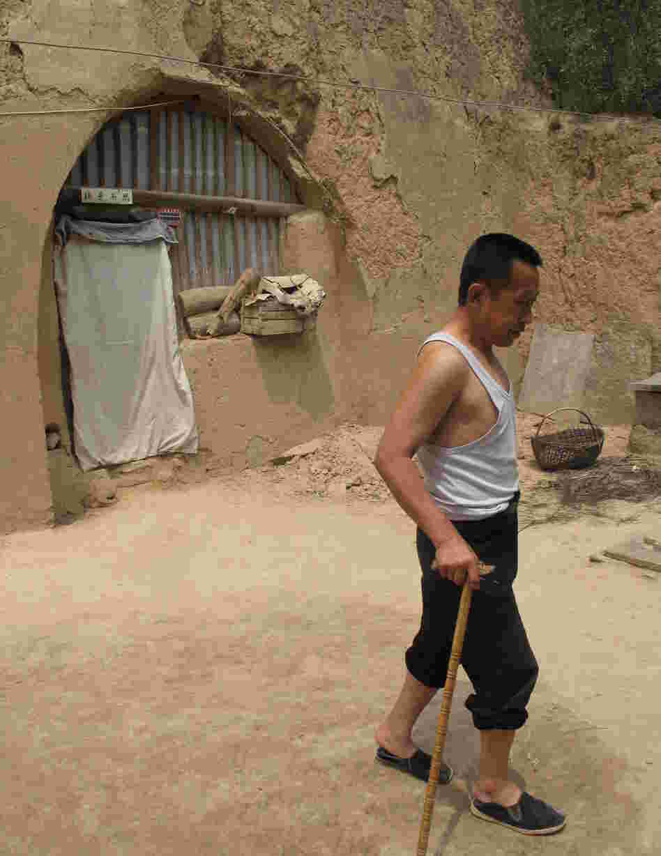 Guo limps across the yard of his cave home, which has no running water. He says he is a big supporter of the Communist Party, but admits he envies city folk, who "live and eat and do everything better than us" country folk. Guo limps across the yard of his cave home, which has no running water. He says he is a big supporter of the Communist Party, but admits he envies city folk, who "live and eat and do everything better than us" country folk.