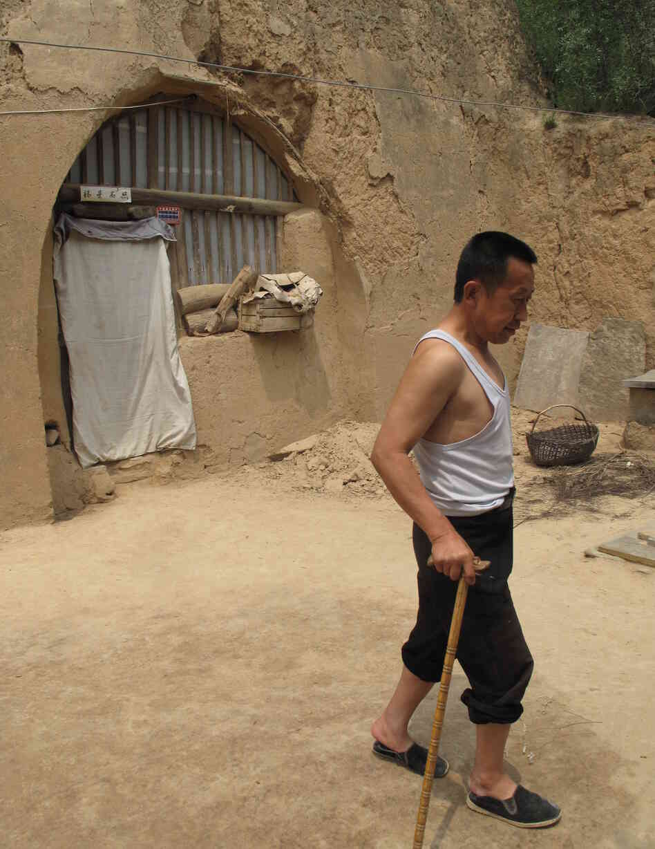 Guo limps across the yard of his cave home, which has no running water. He says he is a big supporter of the Communist Party, but admits he envies city folk, who "live and eat and do everything better than us" country folk. Guo limps across the yard of his cave home, which has no running water. He says he is a big supporter of the Communist Party, but admits he envies city folk, who "live and eat and do everything better than us" country folk.