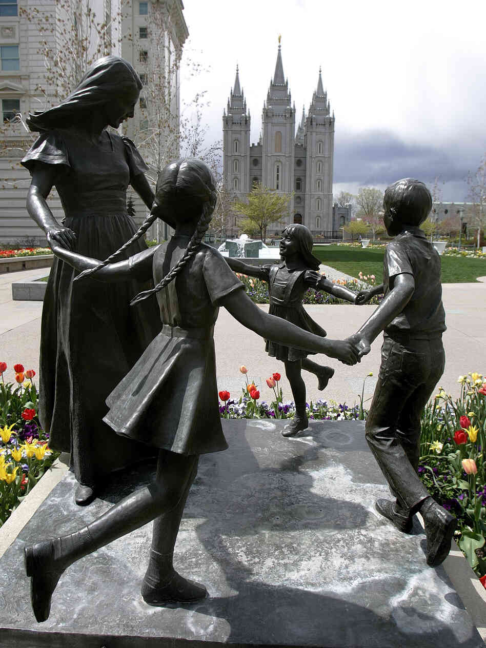 A statue representing womanhood — and women's role in raising children — is seen with the Mormon Temple in the background in Salt Lake City.