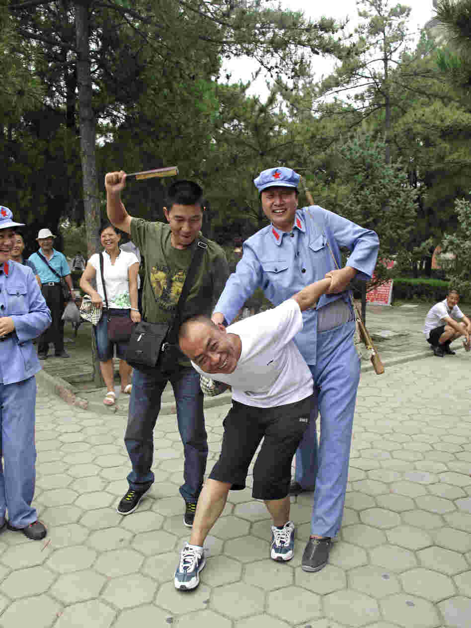 A tourist with a passing resemblance to Chairman Mao put another visitor in a stress position known as the "airplane," which was often used on "class enemies" during the mass upheaval of China's Cultural Revolution, from 1966 to 1976.