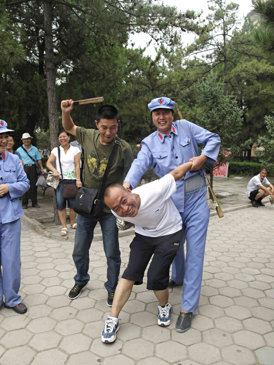 A tourist with a passing resemblance to Chairman Mao put another visitor in a stress position known as the "airplane," which was often used on "class enemies" during the mass upheaval of China's Cultural Revolution, from 1966 to 1976.