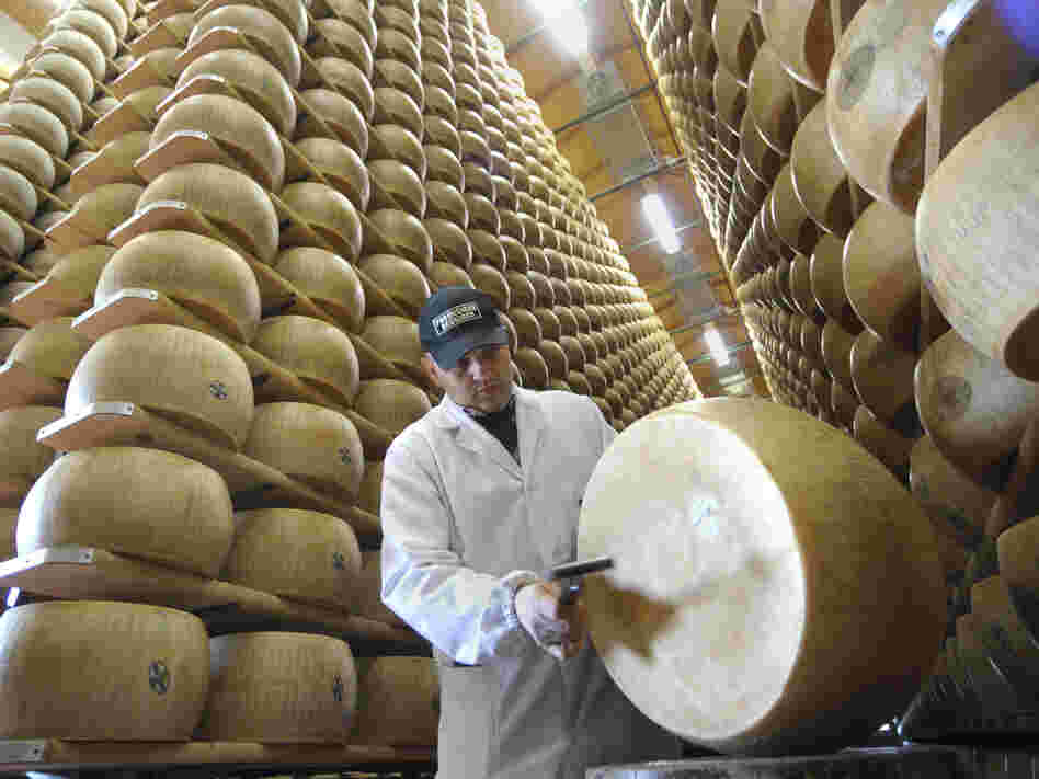 An inspector checks a wheel of Reggiano cheese at the Parmigiano-Reggiano storehouse in Bibbiano, Italy. Earthquakes rocked the region, sending the cheese toppling.
