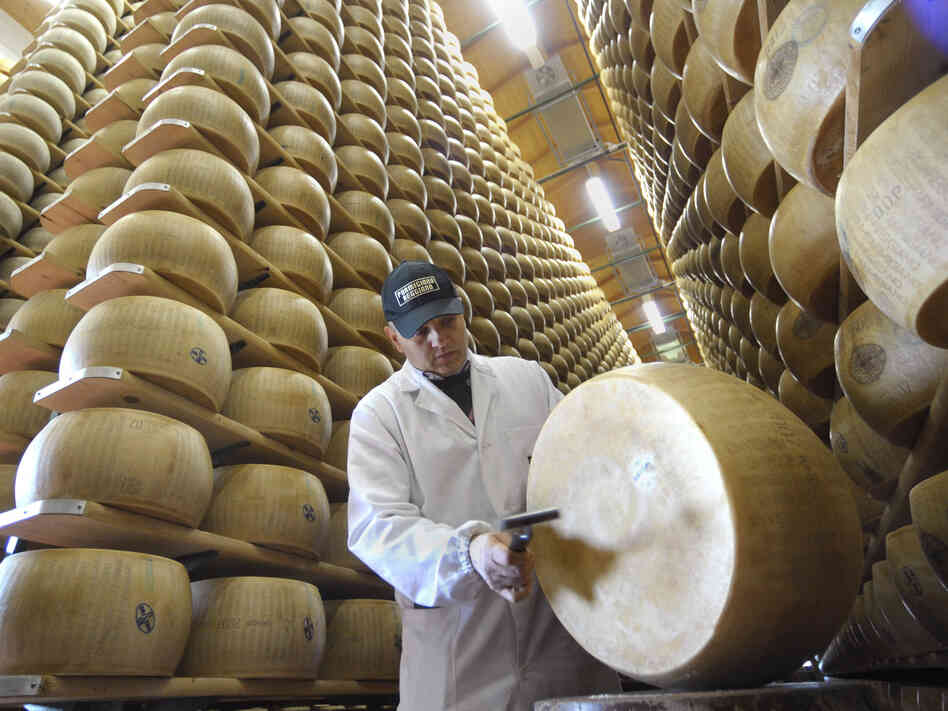 An inspector checks a wheel of Reggiano cheese at the Parmigiano-Reggiano storehouse in Bibbiano, Italy. Earthquakes rocked the region, sending the cheese toppling.