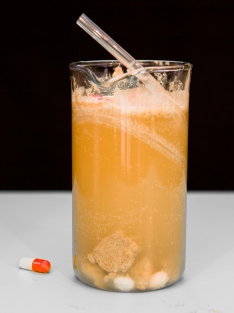 Suicide Stomach Contents: Bartender James Dance of Loading in Cornwall concocted this mixture of flavored vodka, chocolate pieces, skittles, and absinthe, with empty pill casings for garnish, modeled on pathology lab stomach specimen.