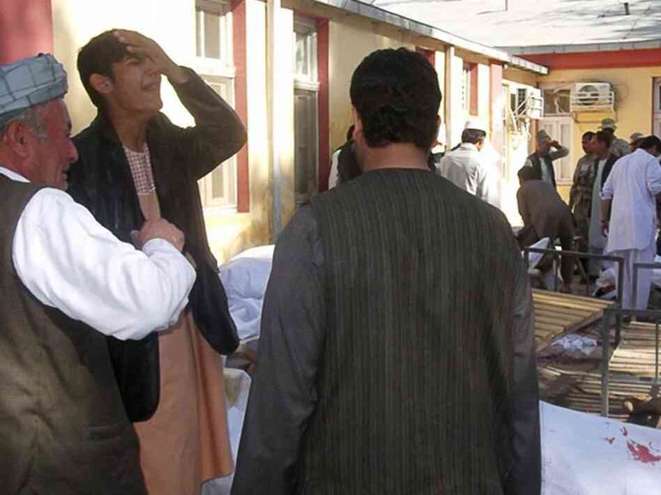 Men mourn beside the bodies of victims from today's suicide bomb attack in Maymana, Afghanistan.