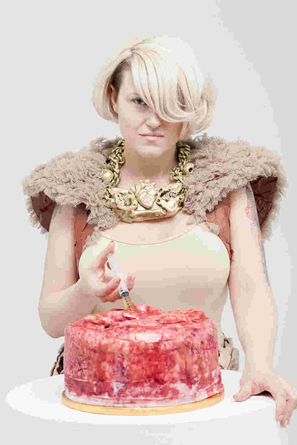 Festival organizer, pathologist, and baker Carla Connolly injects a cake make to look like human flesh in this promotional shot for the museum's bake sale.