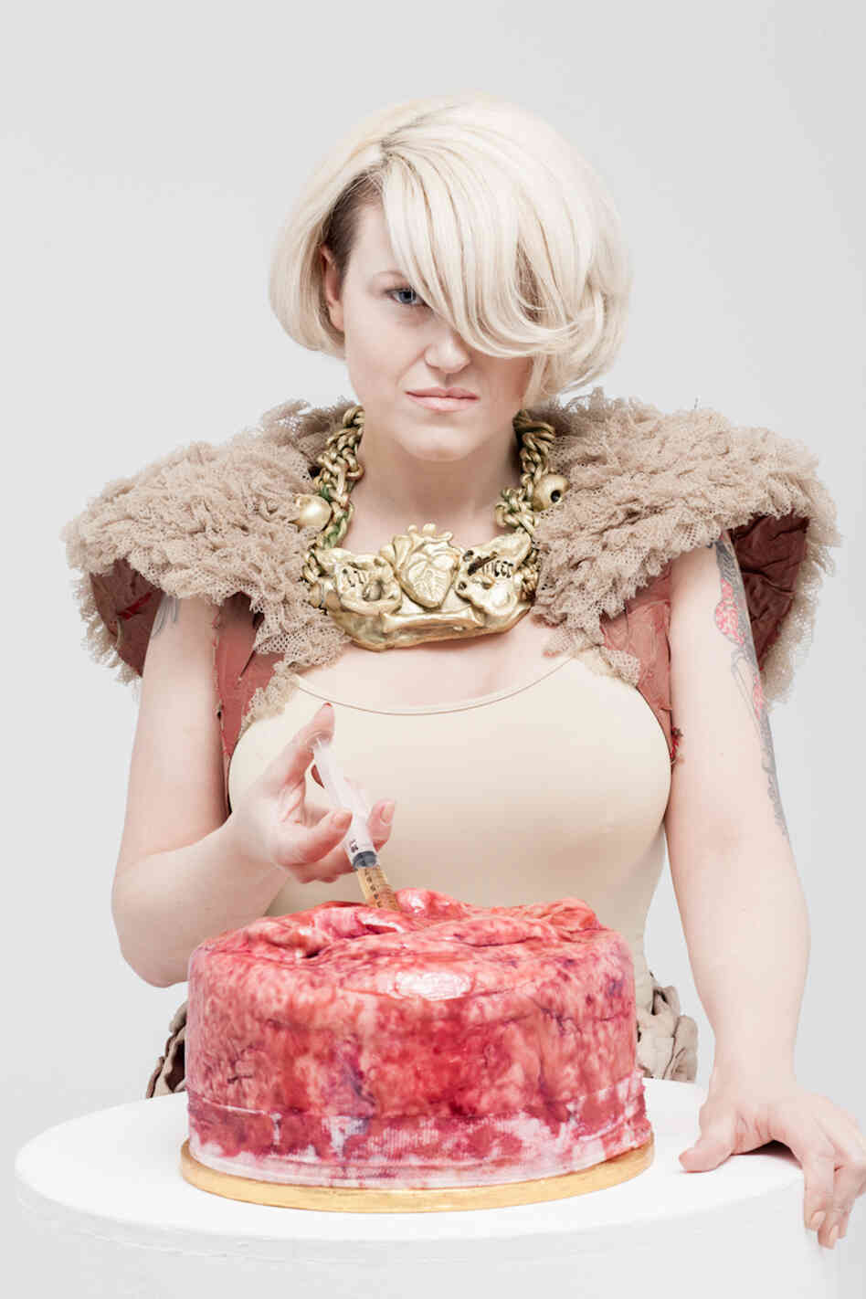 Festival organizer, pathologist, and baker Carla Connolly injects a cake make to look like human flesh in this promotional shot for the museum's bake sale.