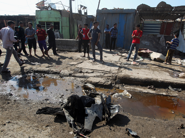 Iraqis inspect the site of a bombing at Al-Bawia market, in east Baghdad, on Saturday.