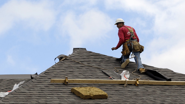 A construction worker finishes a roof in Chicago on Oct. 12. Signs of recovery in the housing market are springing up nationwide, but there's still a ways to go.