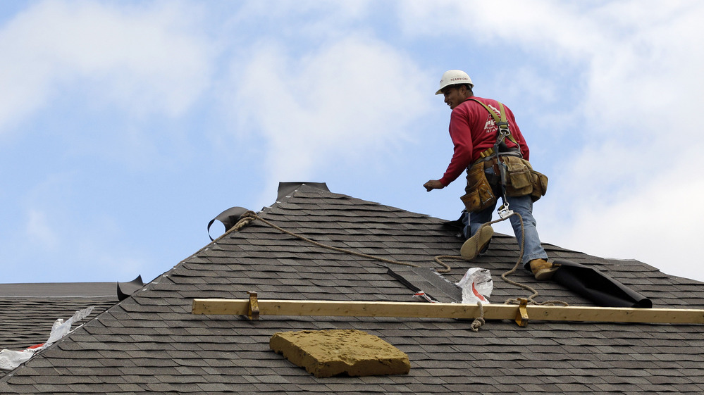 A construction worker finishes a roof in Chicago on Oct. 12. Signs of recovery in the housing market are springing up nationwide, but there's still a ways to go.
