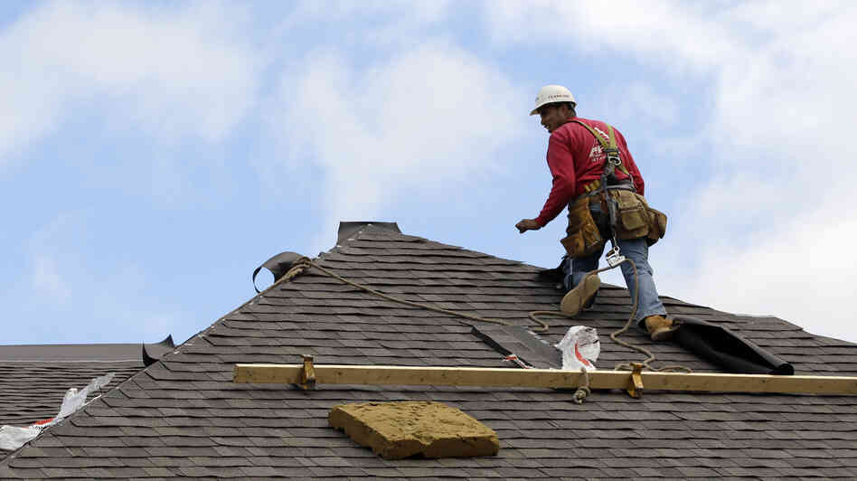 A construction worker finishes a roof in Chicago on Oct. 12. Signs of recovery in the housing market are springing up nationwide, but there's still a ways to go.