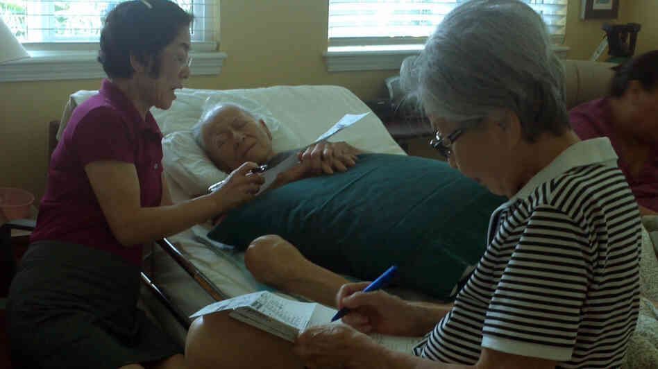 Frank Tanabe votes via absentee ballot with the help of his daughter, Barbara (left) and wife, Setsuko, in Honolulu on Oct. 17. He died the following week.